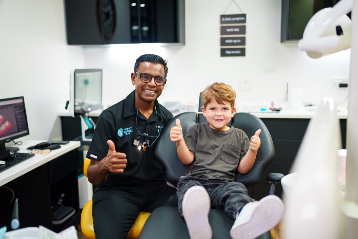 Dr Govender and a child smiling and giving thumbs up