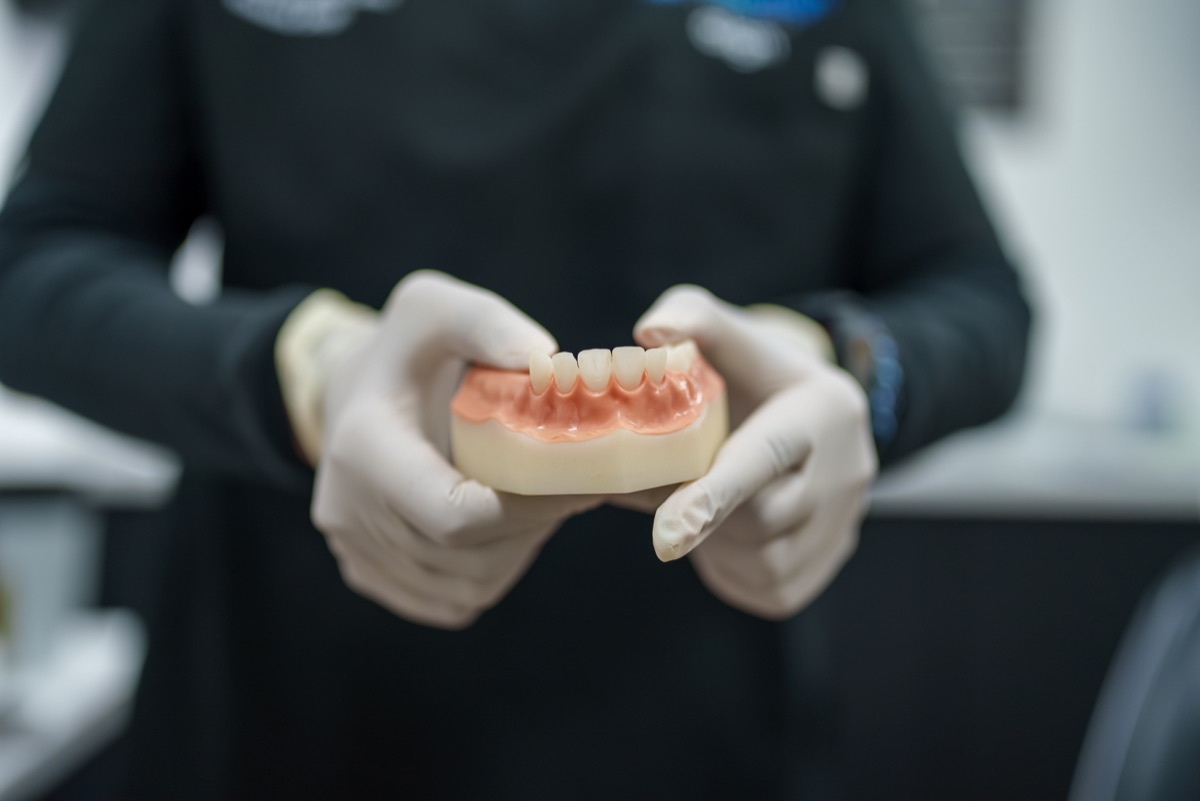 Gloved hands holding a dental model